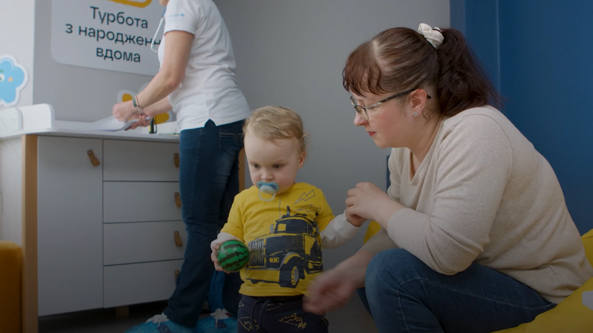 Кадр із серії UNICEF: Мама з дитиною в приміщенні програми турботи про дітей